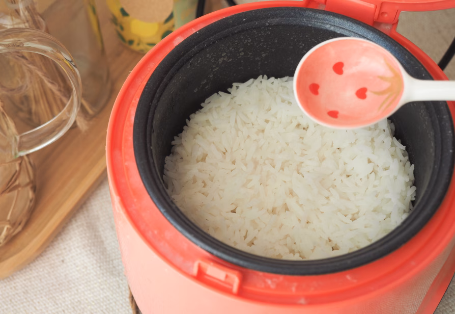 Rice cooker with steaming, freshly cooked rice inside, perfect for effortless meal preparation