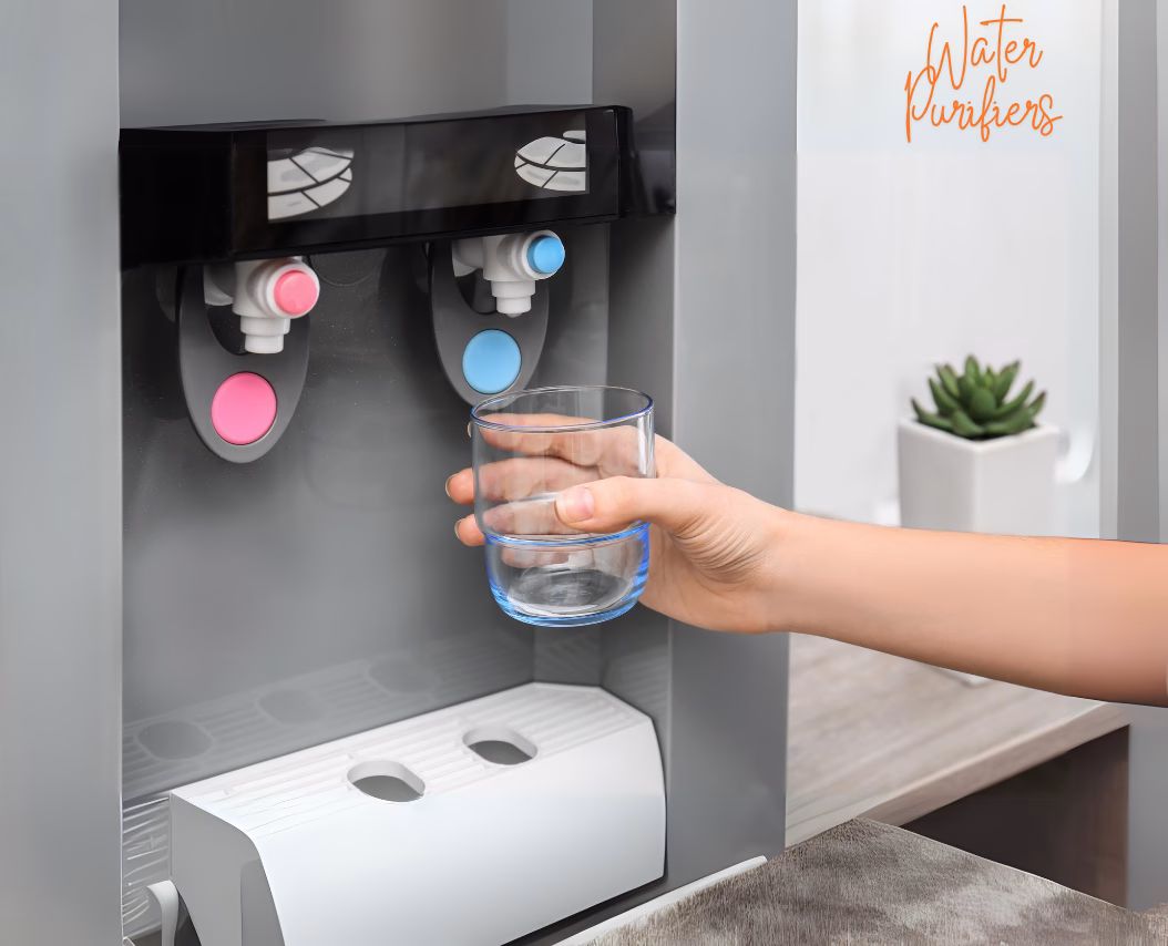 Hand holding a glass under a modern water purifier dispenser with hot and cold water taps